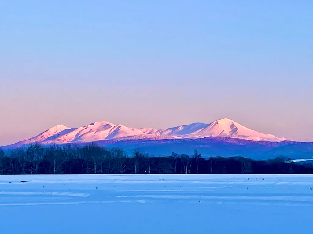 夕日に染まる大雪山連峰と雪原（東神楽町）