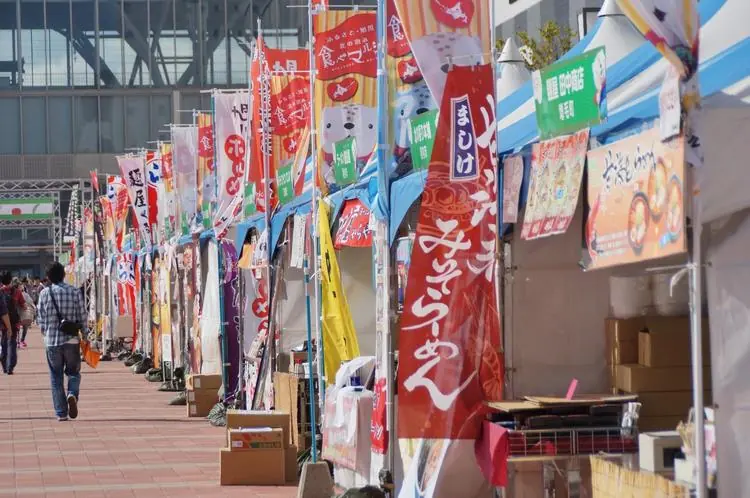 のぼりを掲げた屋台が並ぶ食べマルシェの駅前広場会場