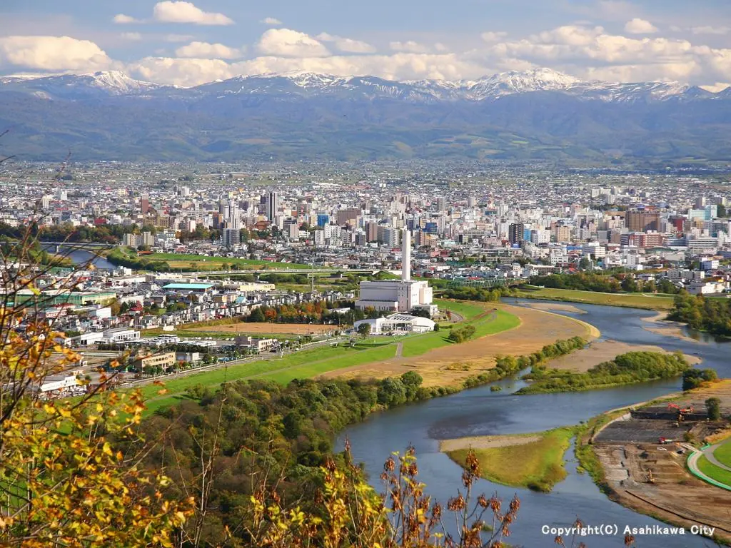 嵐山展望台から見た旭川の市街地と川、その向こうの雪山